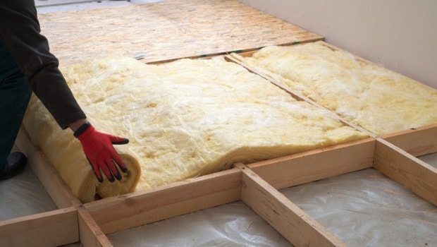 worker adding attic insulation